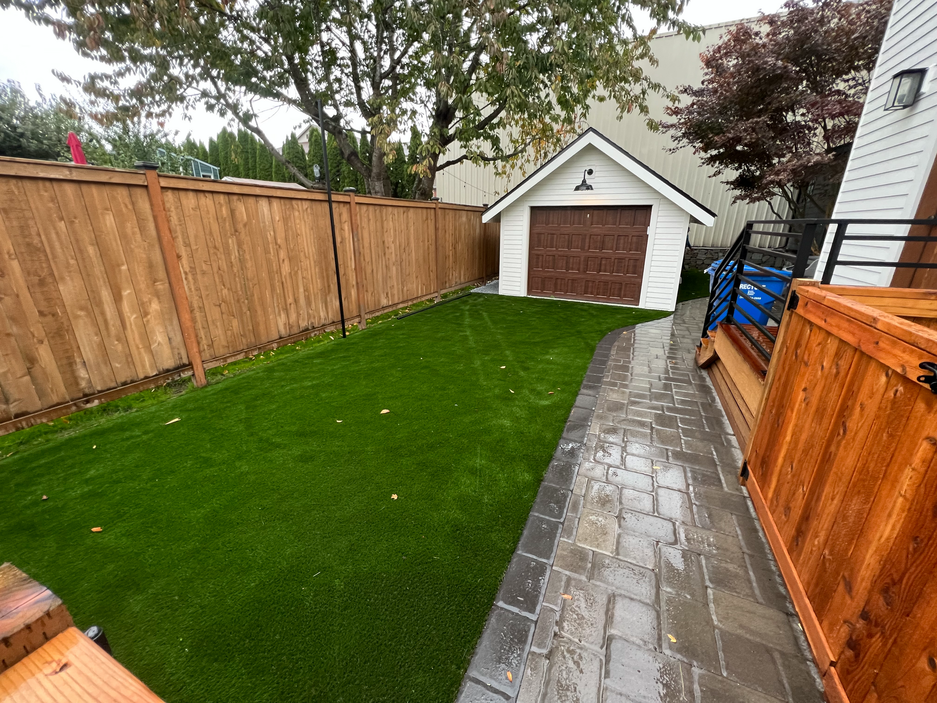 A backyard with a wooden fence and a garage.