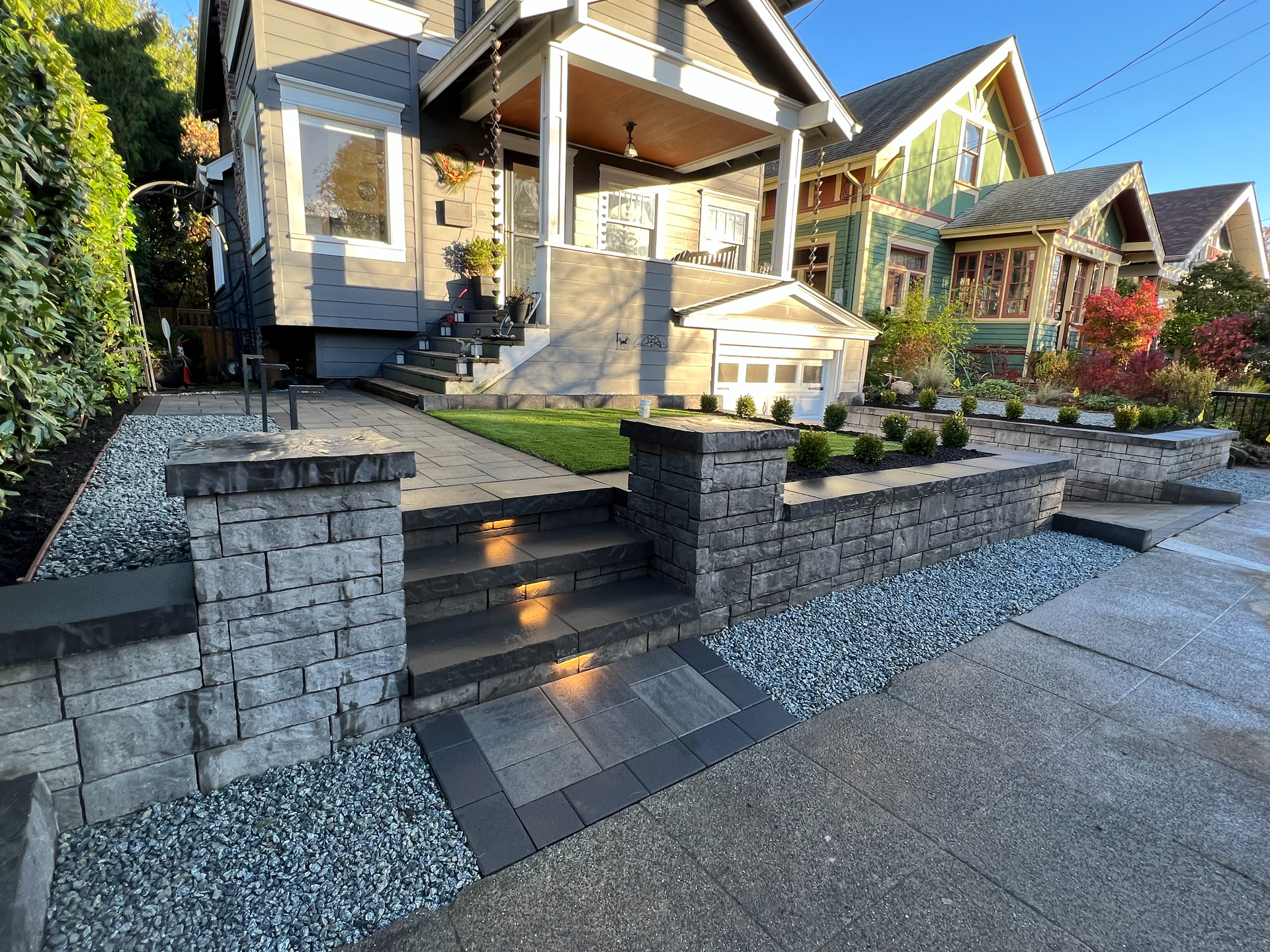 A wooden fence surrounds a lush green lawn in a backyard.