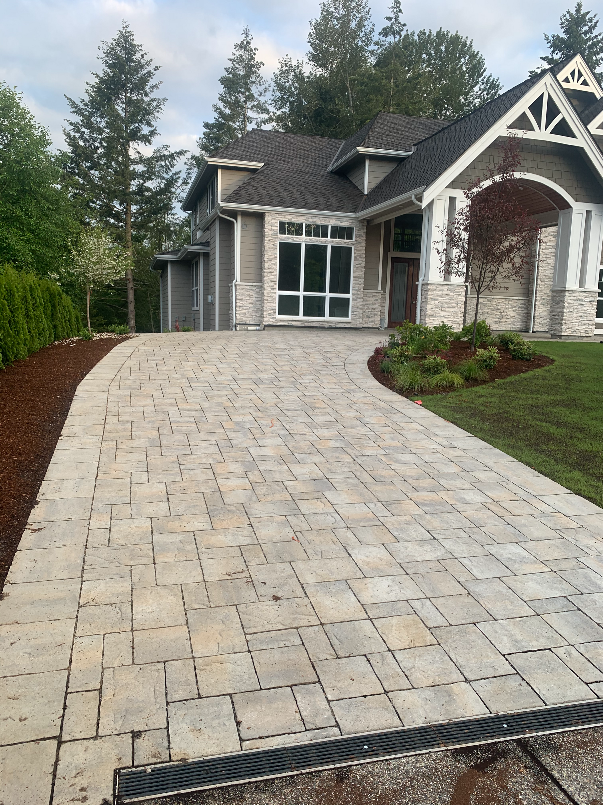 A large house with a brick driveway leading to it