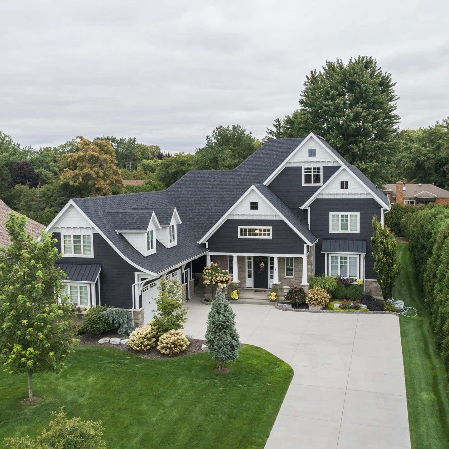 An aerial view of a large black and white house