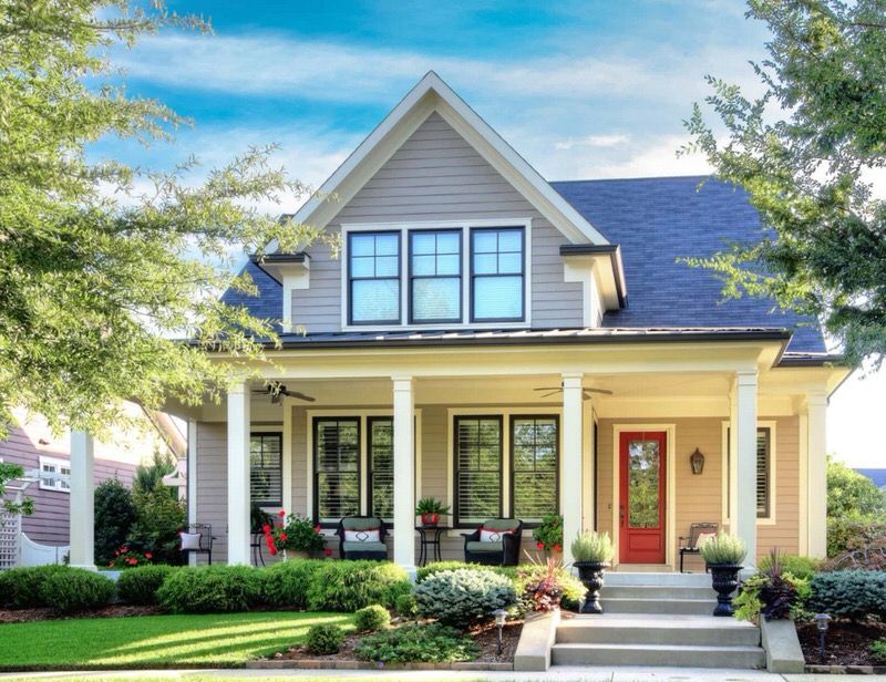 A warm yellow house in James Hardie fiber cement siding with gray and black accents and white trim.