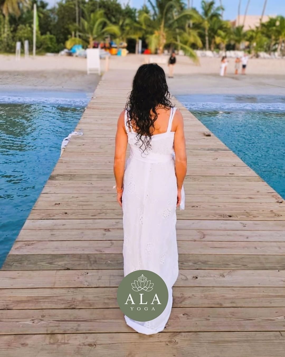Mujer en pose de yoga de perro boca abajo en un césped verde de un parque.