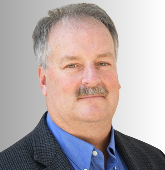 Mark Hueteen Profile Picture - a man with a mustache is wearing a suit and blue shirt .