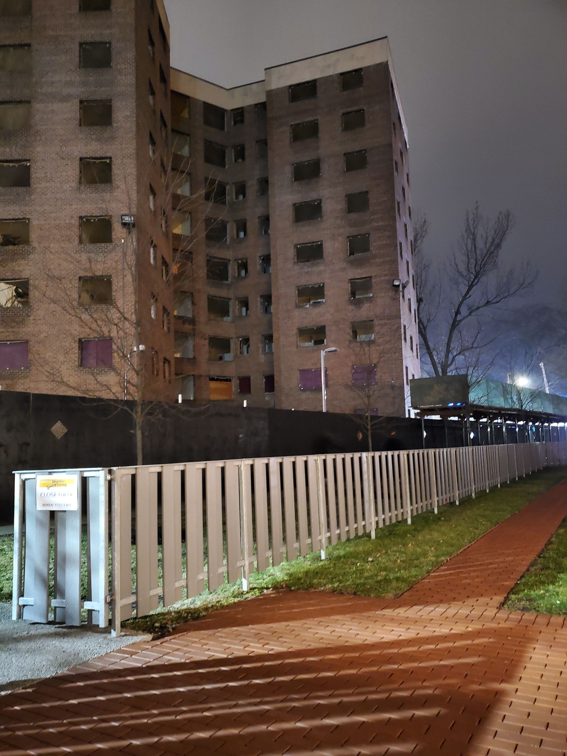 Scaffolding on a building facade, with gray insulation and orange metal supports.