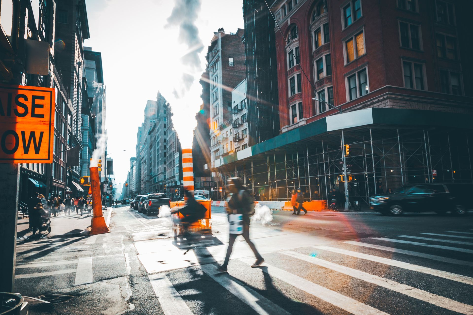Construction worker on scaffolding at a building site with green support structures and concrete pillars.
