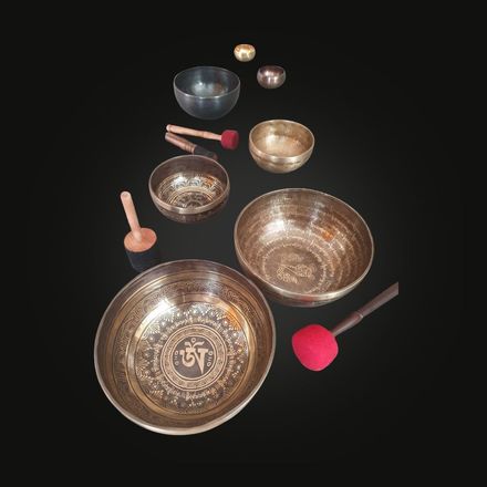 Handmade 7-metal singing bowl from Nepal with chakra symbols engraved, representing energy centers from root to crown.
