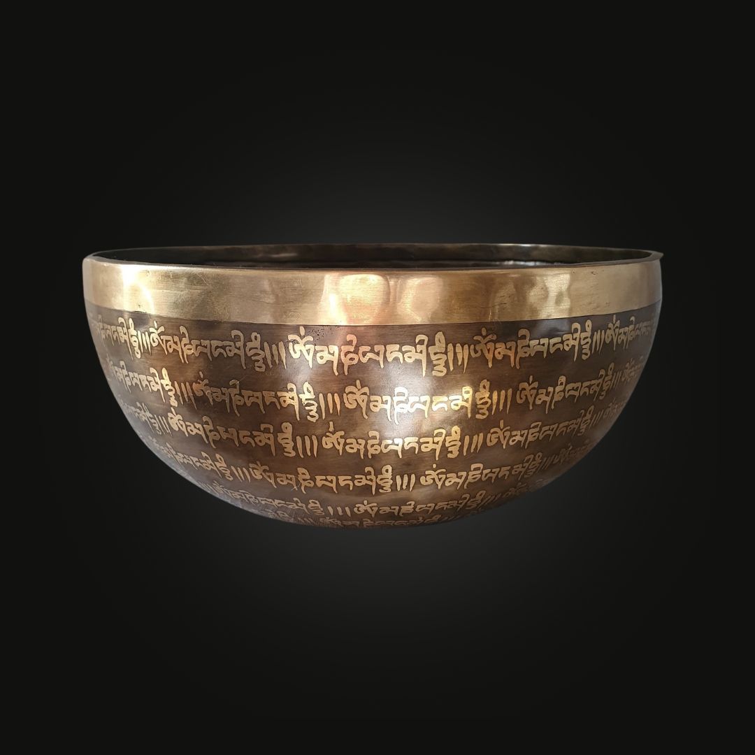 Handmade 7-metal singing bowl from Nepal with chakra symbols engraved, representing energy centers from root to crown.
