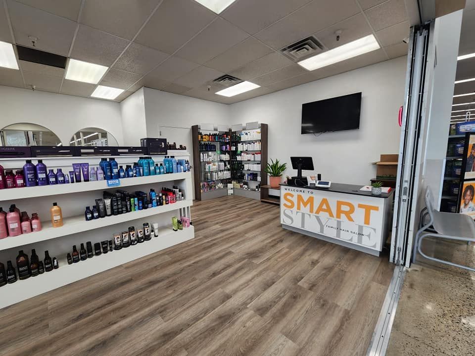 The inside of a hair salon with a counter and shelves filled with hair products.