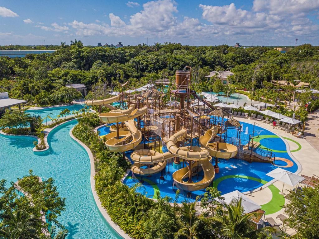 An aerial view of a water park with a lot of water slides surrounded by trees.