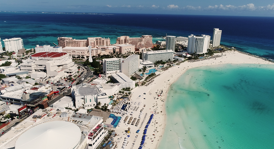 An aerial view of a beach with a lot of people on it.