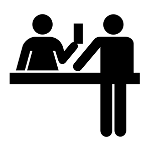 A man is giving a ticket to another man at a counter.