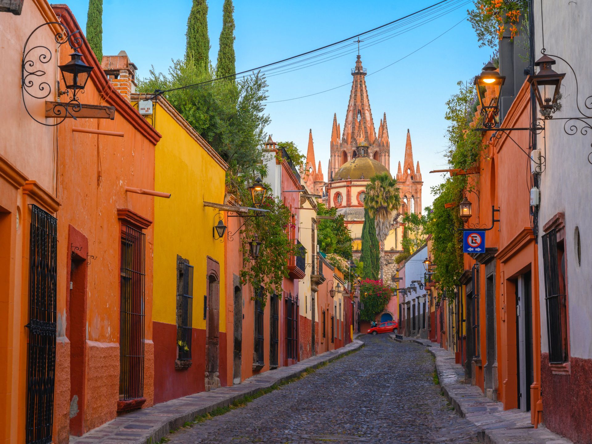 A narrow cobblestone street with a church in the background.