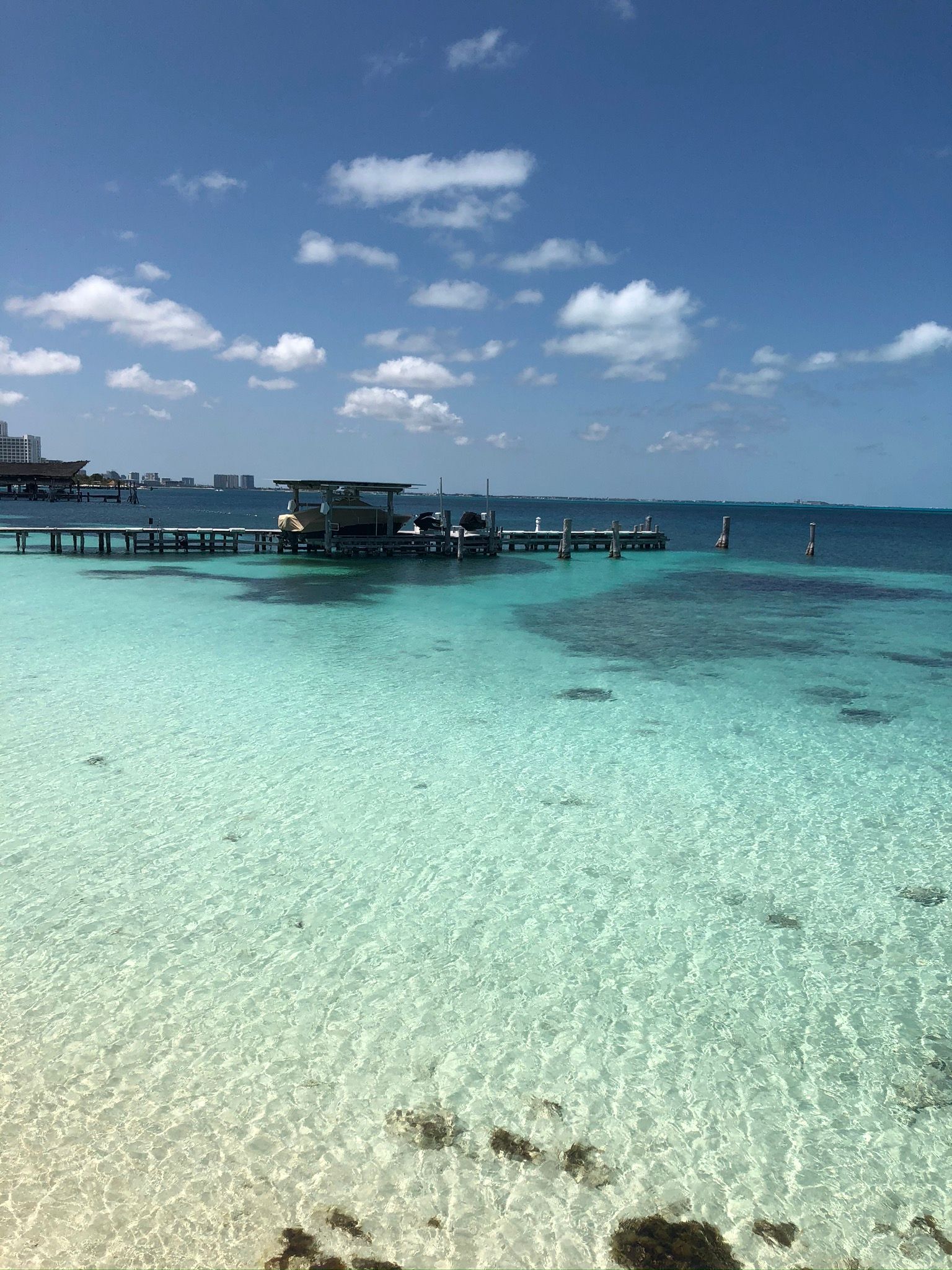 Cancun  beach with a pier and boats in the water