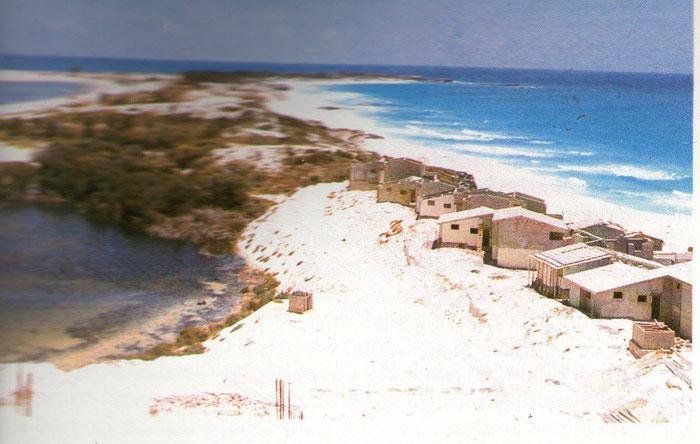 A group of houses on a hill overlooking a body of water