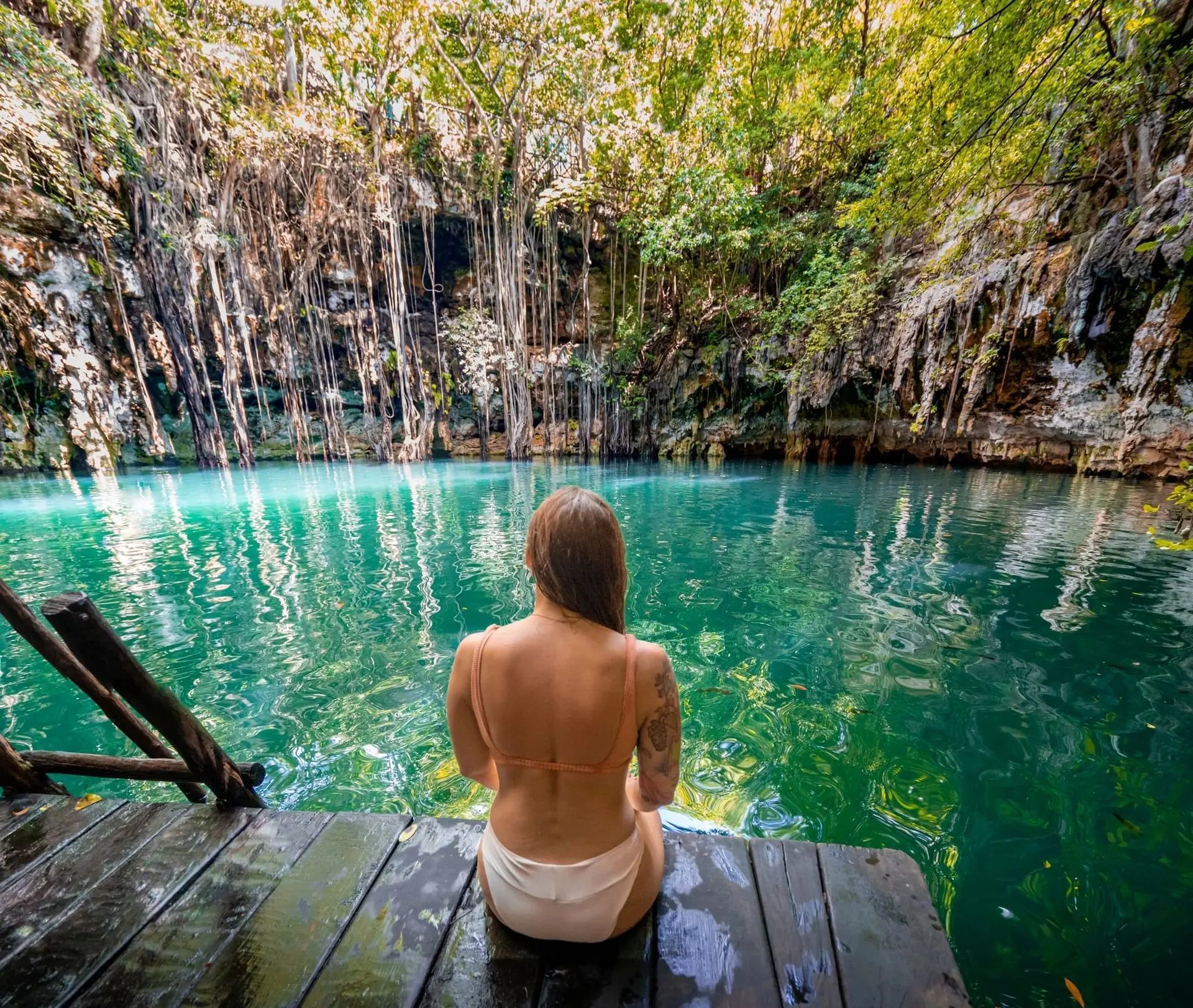 A large pool of water in a cave with stairs leading up to it.