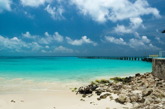 A beach in Cancun with a dock.