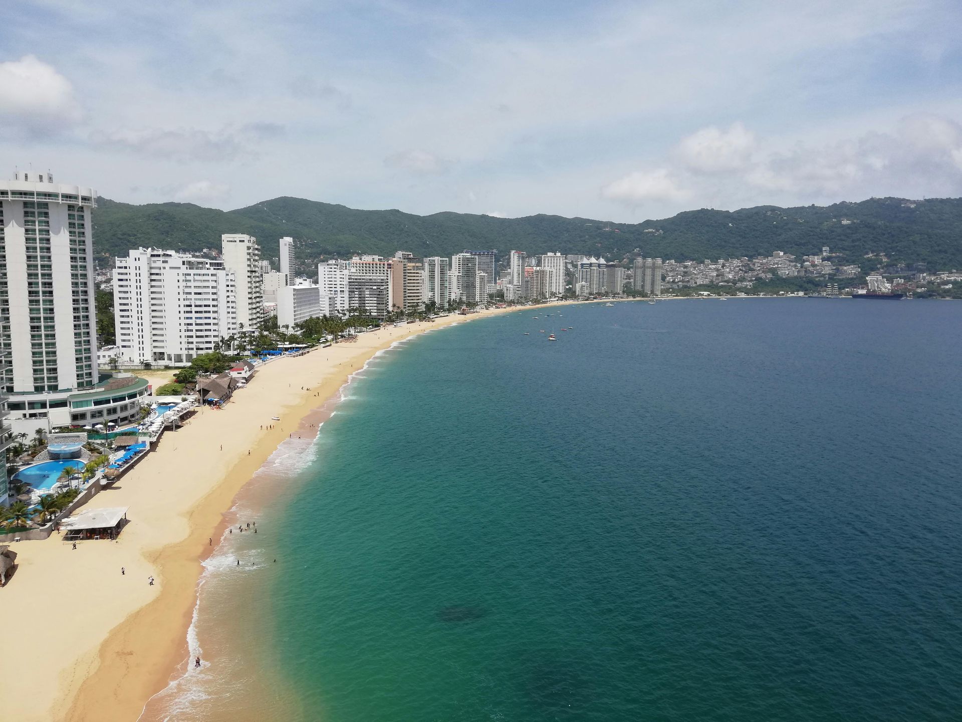 An aerial view of a beach with a city in the background