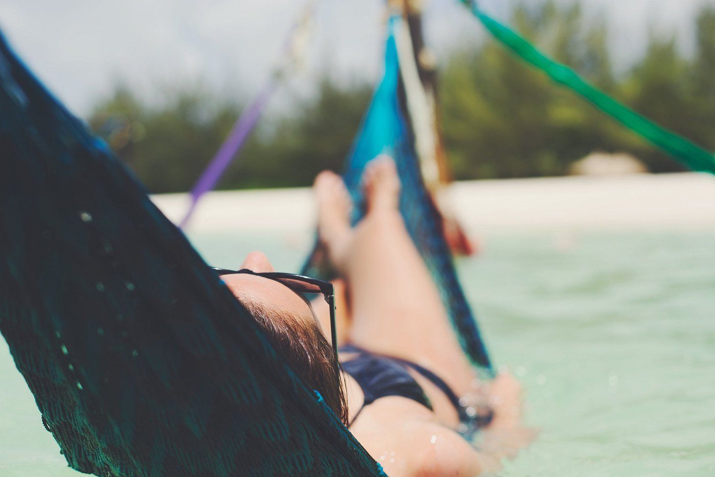 Una persona relajada sobre una hamaca en el mar.