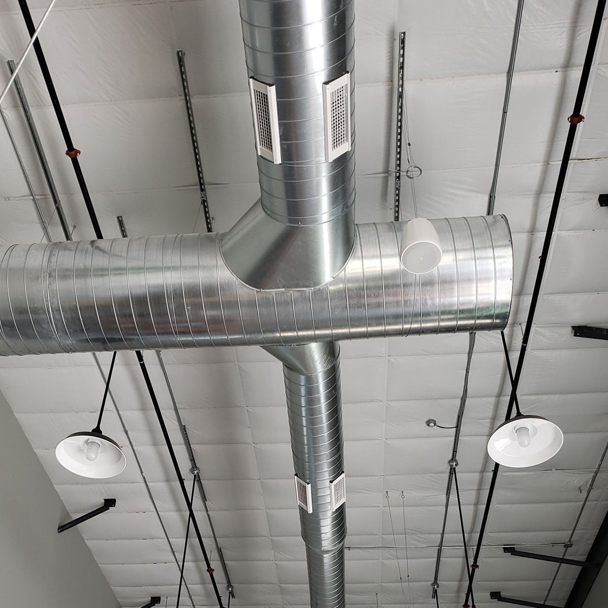 A metal pipe is hanging from the ceiling of a building