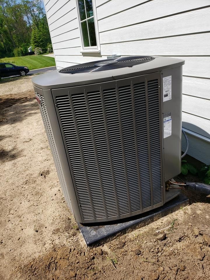 A large air conditioner is sitting on the side of a house.