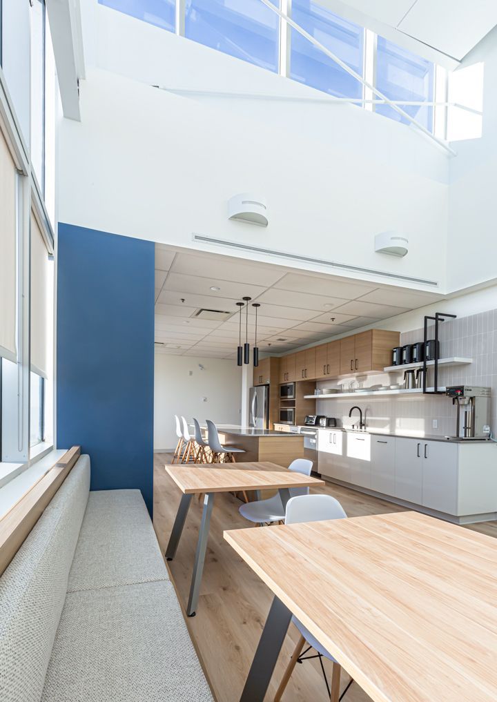 A kitchen with a lot of windows and tables and chairs.