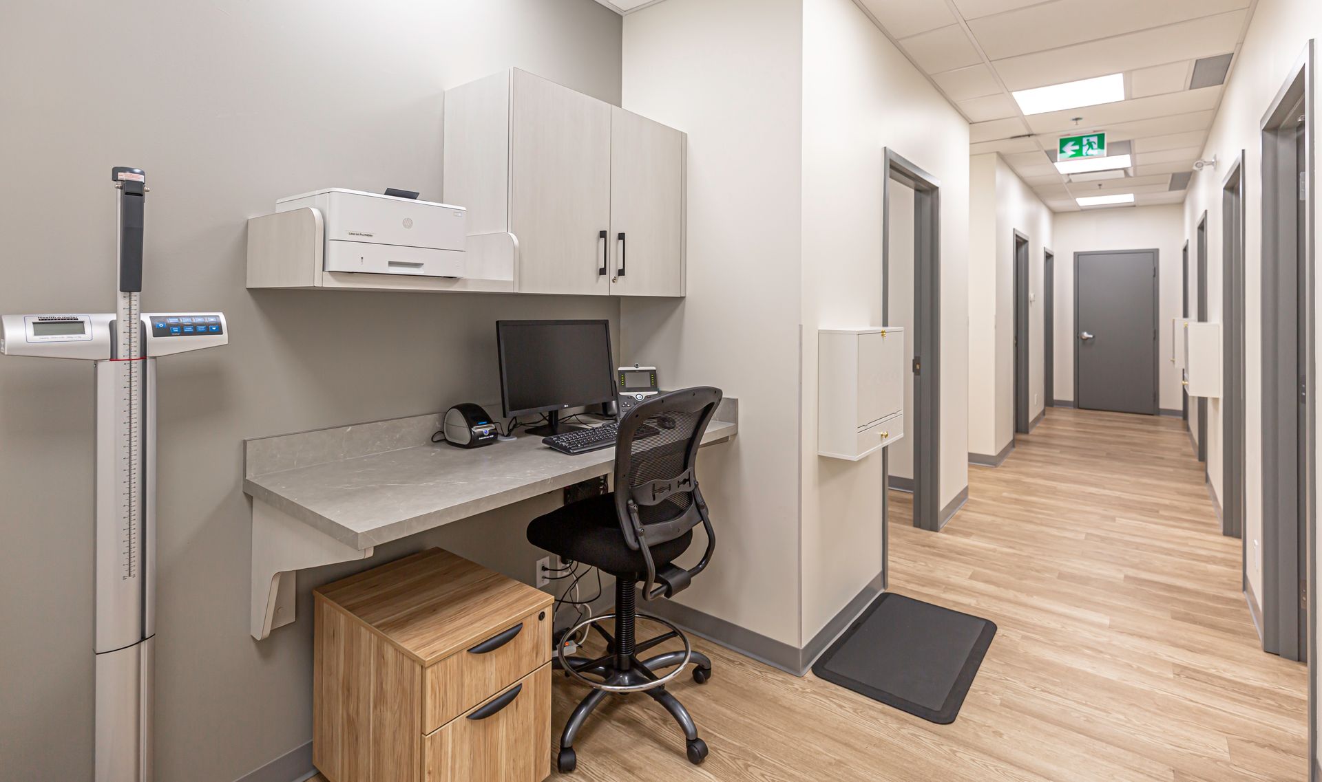 There is a desk with a computer on it in a hallway.