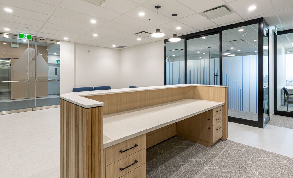 A large empty office with a wooden desk and drawers.