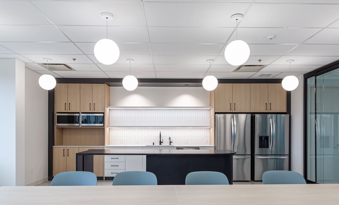 A kitchen with a table and chairs and a refrigerator.