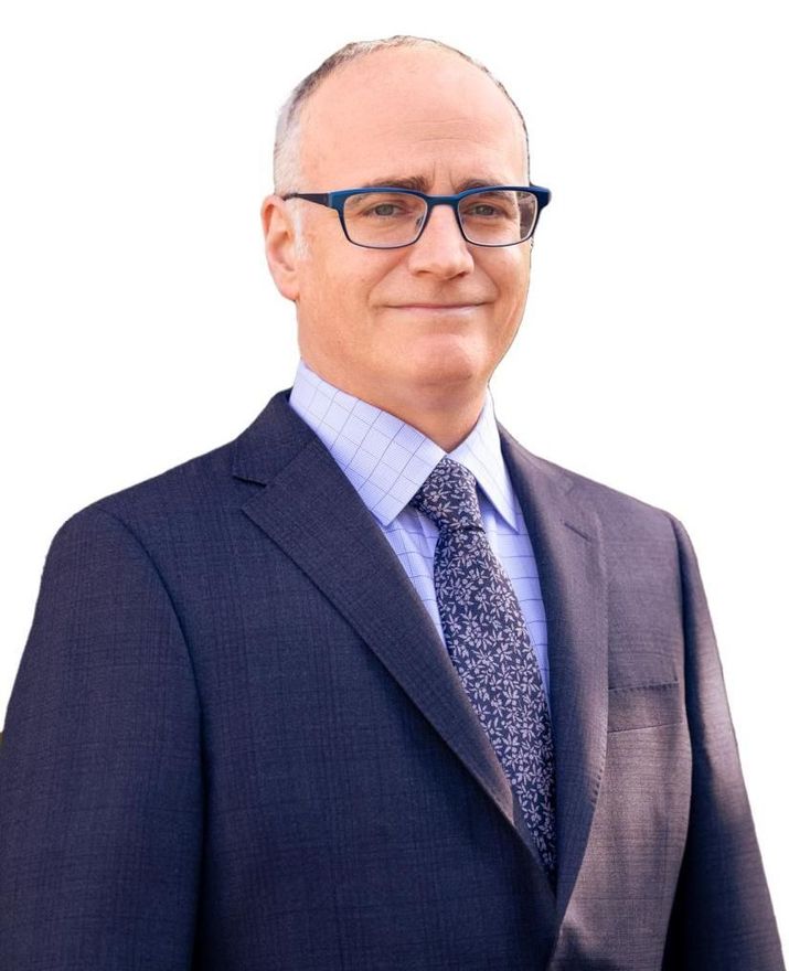 A man in a suit and tie is wearing glasses