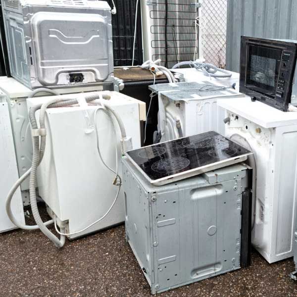 a bunch of old appliances are sitting on the ground .