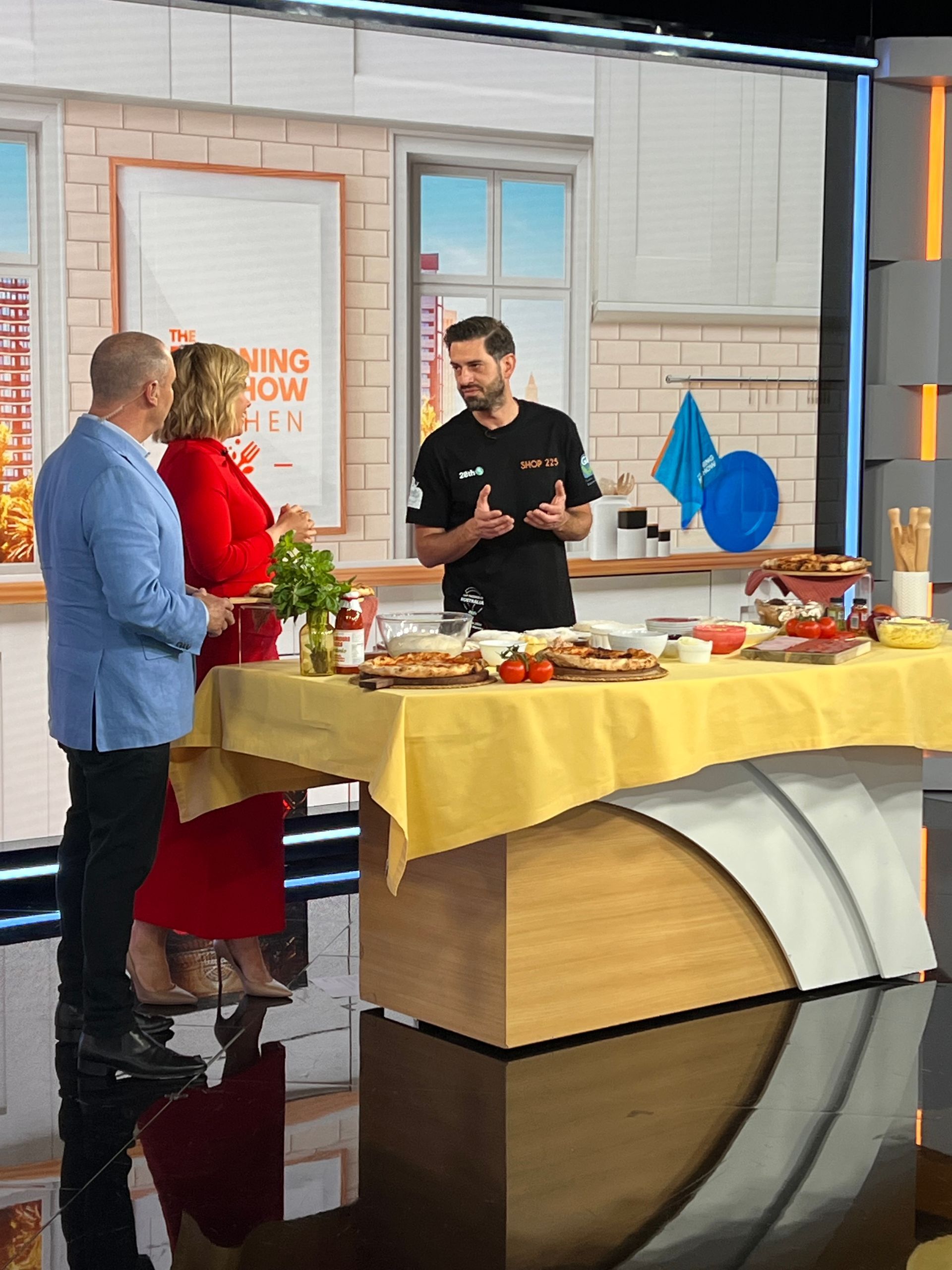 Lorenzo explain the pizza toss to the host of Channel 7