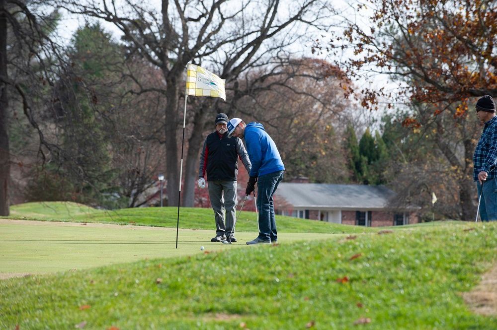 A group of people are playing golf on a golf course.