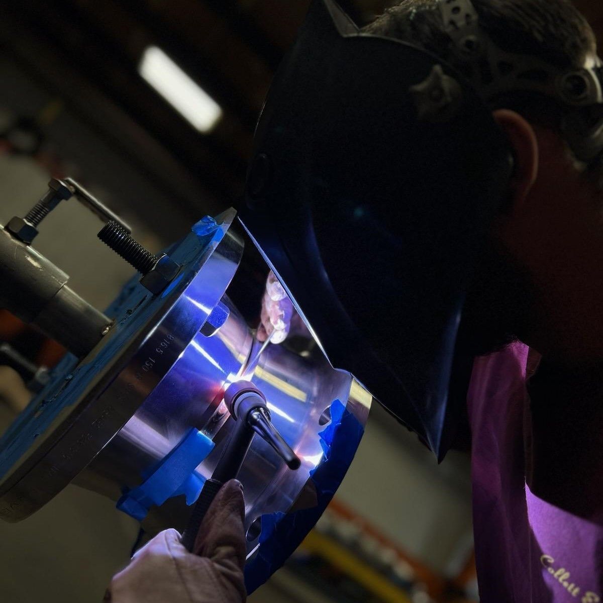 A yellow pipe with welding & mfg inc. written on it