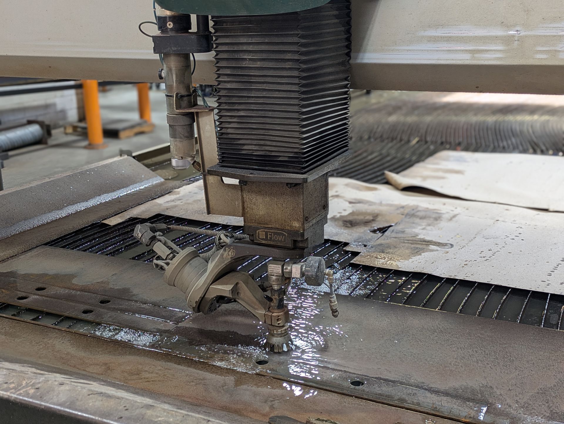 A machine is cutting a piece of metal with water