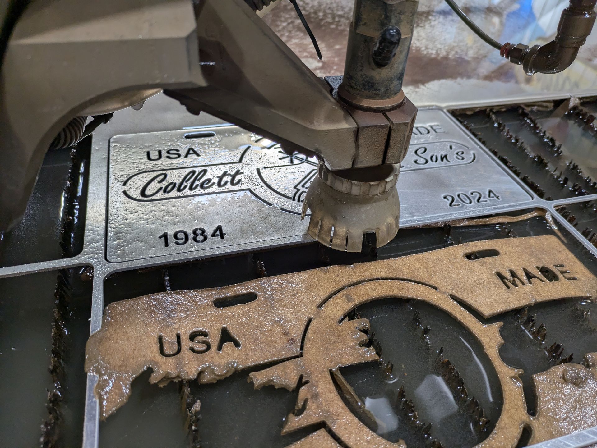A machine is cutting a piece of wood that says usa collect 1984