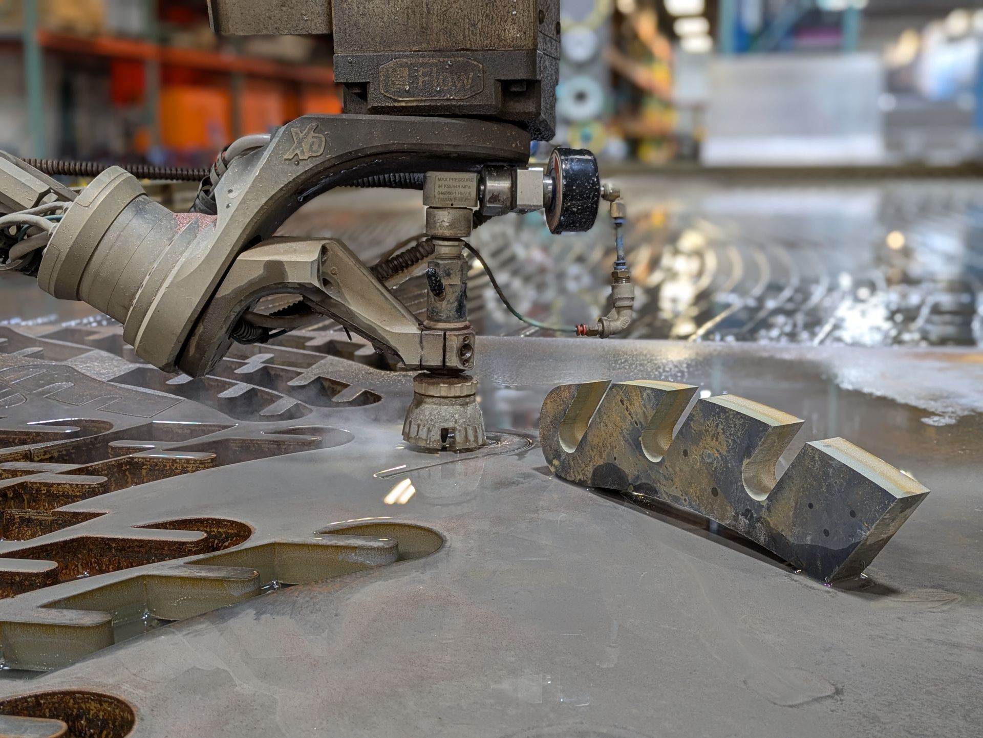 A machine is cutting a piece of metal with water.