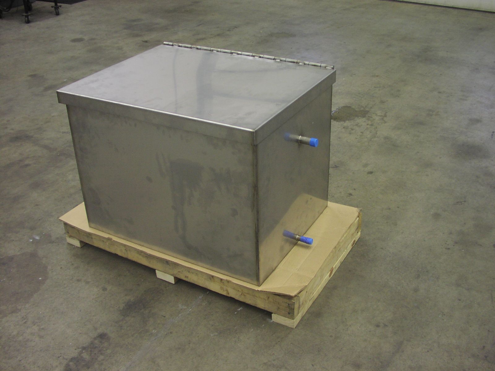 A stainless steel box is sitting on a wooden pallet