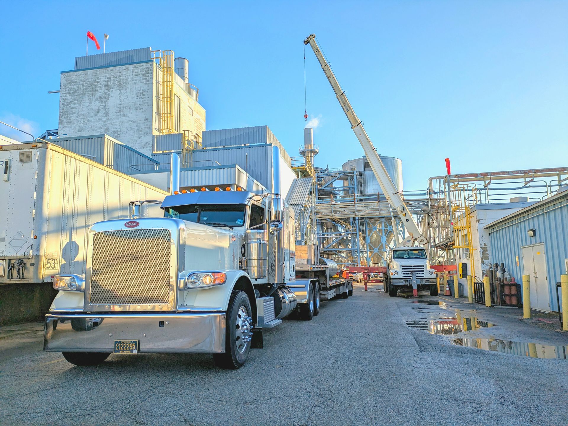 A row of semi trucks are parked in front of a building.