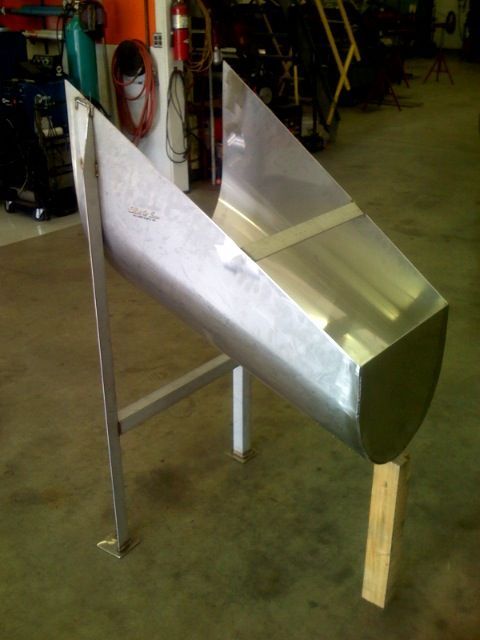 A stainless steel container is sitting on a wooden stand