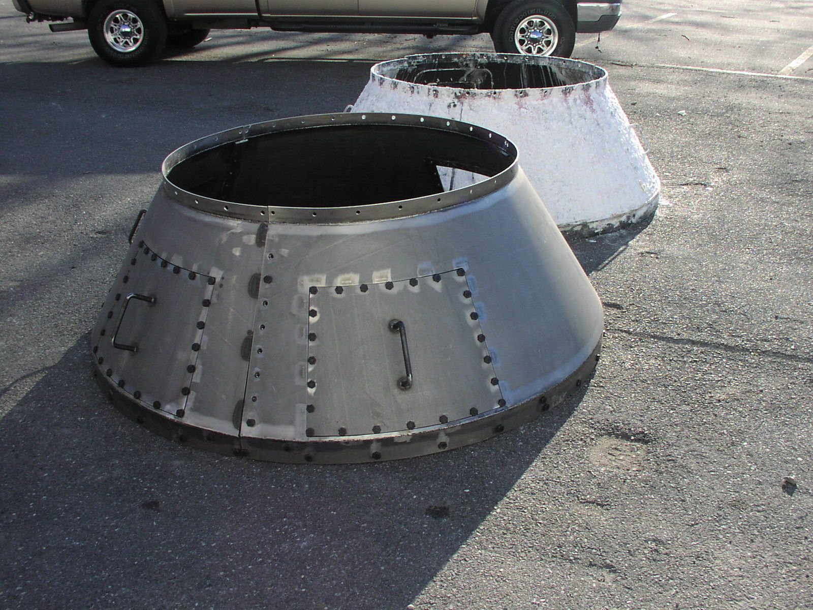 Two metal cones are sitting on the ground next to a truck