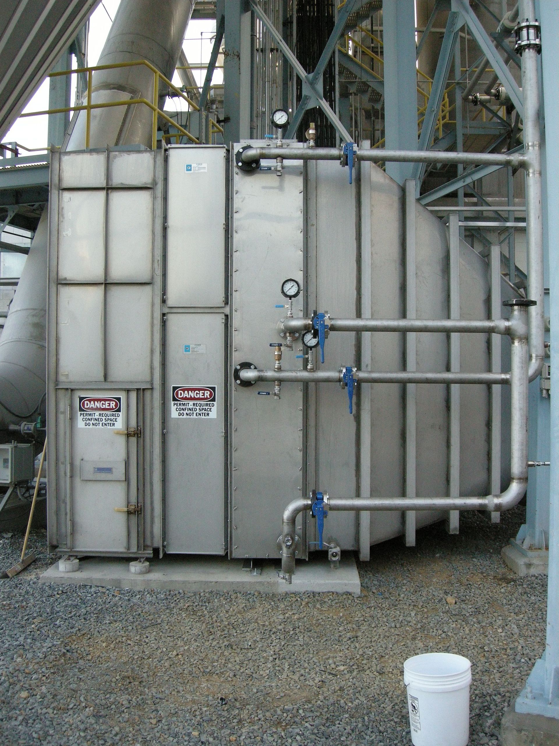 A stainless steel container with a danger sign on it