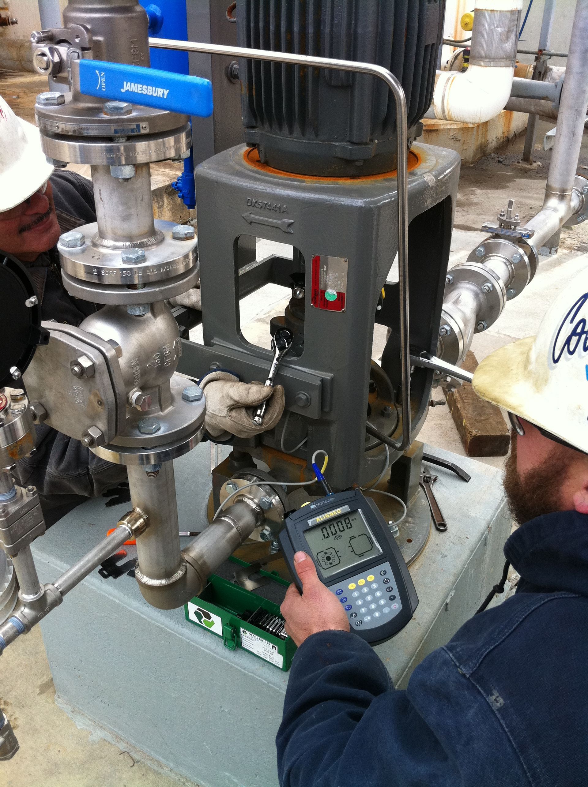A man wearing a hard hat is working on a machine