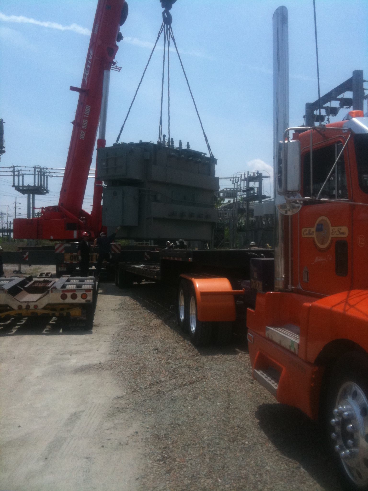 A semi truck with a trailer attached to it is parked in a gravel lot.