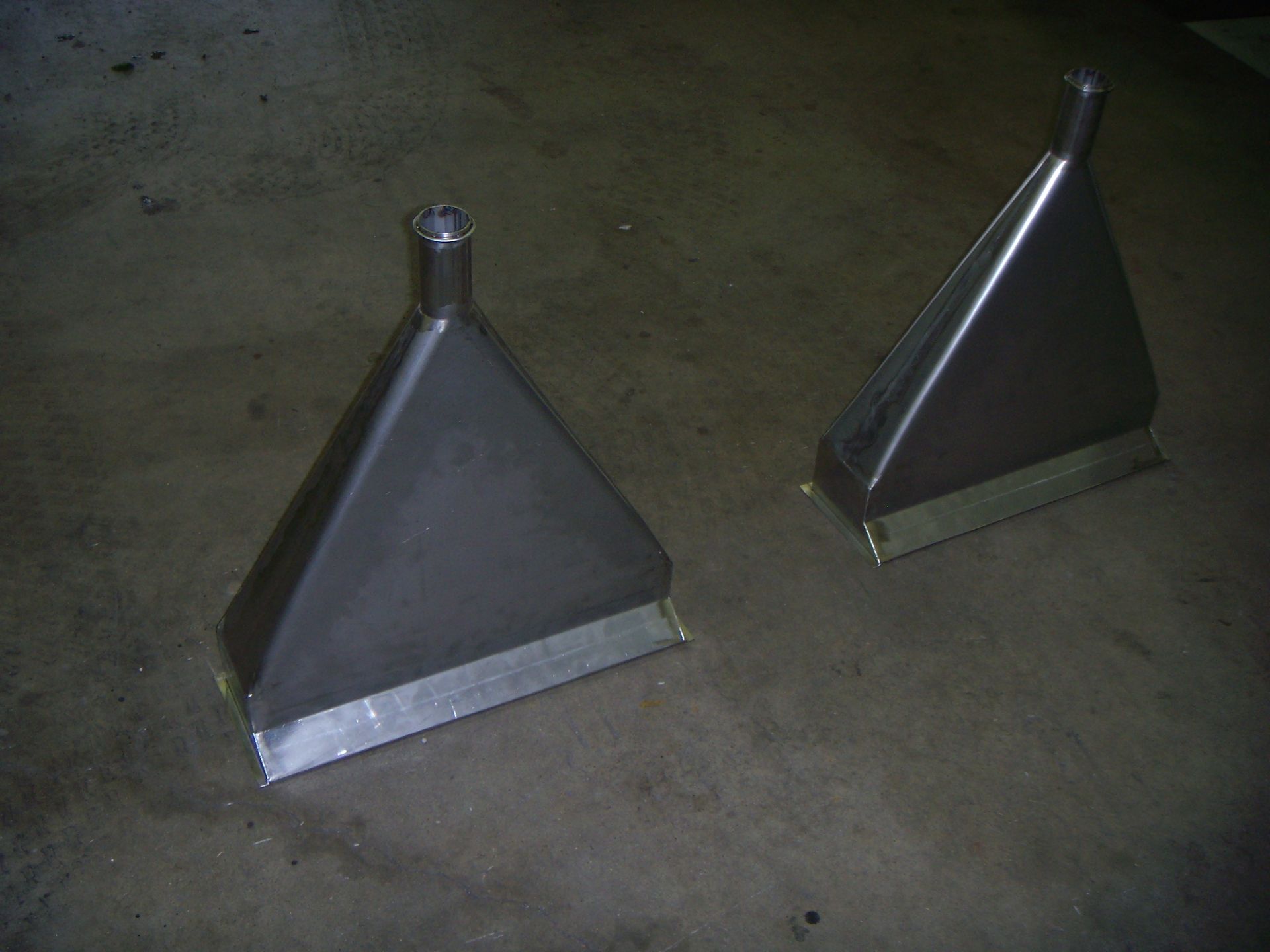 Two metal triangles are sitting on a concrete surface