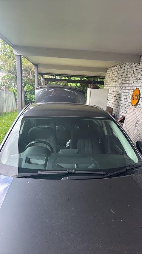 A Black Car is Parked Under a Canopy in a Driveway — Morayfield Autoglass in Caboolture South, QLD