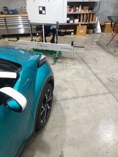 A Blue Car is Sitting in a Garage Next to a Machine — Morayfield Autoglass in Caboolture South, QLD