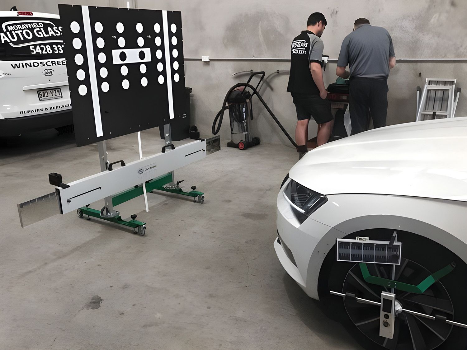 Technicians Performing ADAS Calibration On A Vehicle In A Workshop