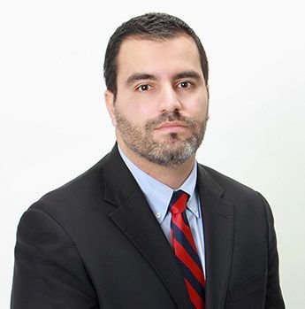 A man in a suit and tie is standing in front of a dictionary page.