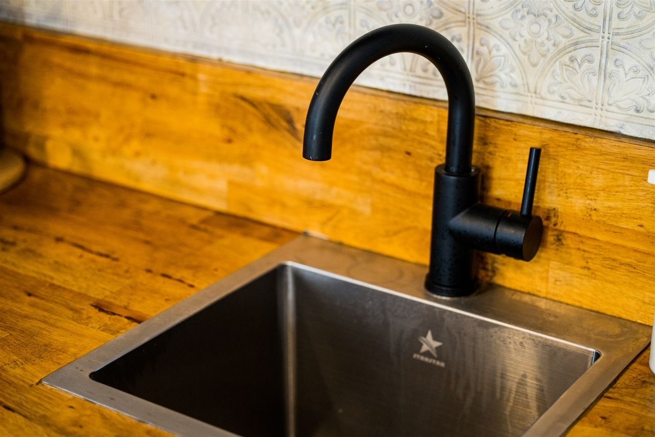 a stainless steel sink with a black faucet on a wooden counter .