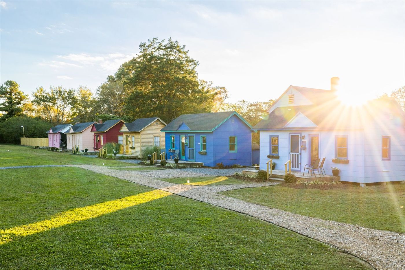 A row of colorful houses in a small town with the sun shining through the windows.
